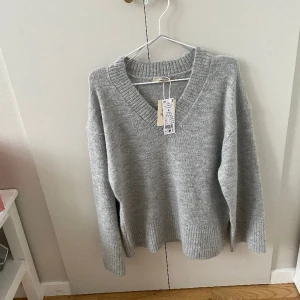 Stickad tröja - Säljer en v-ringad grå tröja från Gina tricot. Den är helt oanvänd med prislapp kvar. Köptes för 400 och säljer för 350:  Det är i Ginas premium qualiy, wool blend.   ❗️köparen står för frakten❗️