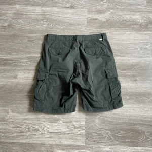 Levis cargo shorts - Levis gröna cargo shorts. Ytter/innerben längd: 53.5cm/23.5cm. Midja: 44cm. Benöppning: ca 28cm. 
