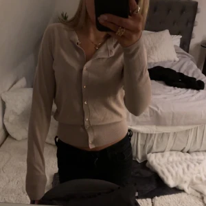 Stickad kofta  - Fin kofta med guldiga knappar som inte är använd vid många tillfällen, en knapp har lossnat men extra identisk knapp medföljer