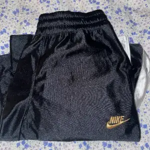 Nike flared baggy byxor med vita ränder och knappar på sidorna. Knappt använt och inga defekter. Dm vid intresse/frågor!💕( Köpt på Nike för 899kr ) 