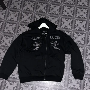 Bling Lucid Rhinestone hoodie - Säljer en fet Blinglucid hoodie som inte är min stil längre så har inte haft någon användning för den, tröjan är i väldigt bra skick och använd 2-3 gånger. Skick -9/10 nypris -800kr, mitt pris -499kr. Hör av dig vid intresse eller om du har frågor!