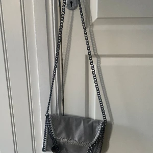 Grå handväska  - Grå Stella McCartney väska. Använd men fint skick och säljer pågrund av att den inte kommer till användning. Super fin till sommaren och rymlig väska.💕