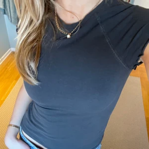 Mini T-shirt  - Såå snygg mini T-shirt från weekday. Sitter tajt och är typ aldrig andvänd. Den är svart men typ ljus svart/mörk grå