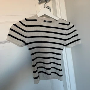 Randig topp - Säljer denna randiga stickade toppen från Gina Tricot då den inte används längre 🤍 den är använd ca 4 ggr 🥰 den är superskön och formar kroppen fin också väldigt populär! 