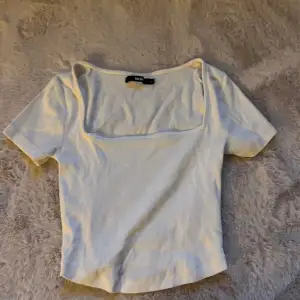 En vit T-shirt, lite kortare i modellen 