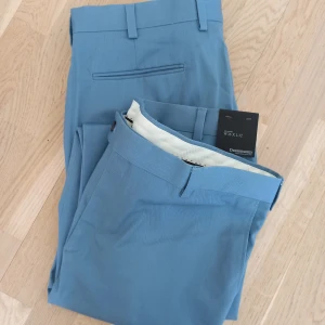 Två blåa kostymbyxor - Två stycken snygga, blå kostymbyxor från dressmann!  Stl W36 L32, båda två.  De är helt nya och aldrig använda. Köp ett par för 130 eller båda för 230🌟