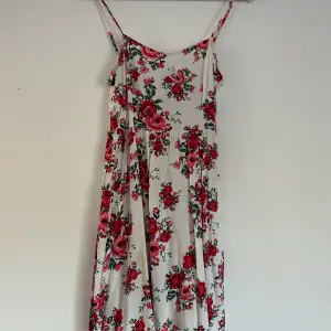 Så fin vit klänning med röda blommor på!! Den är i storlek 36! Den har en liten gul fläck men inget som syns så mycket när man har på sig den! Den kan gå bort i tvätten men vet ej! Säljer för 40kr 🩷