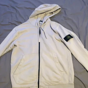 Stone island zip - Väldigt snygg och skön stone island zip tröja, Cond 7/10 lite sliten och ett litet hål i högra arm ( hade några andra hål innan som har blivit ihopsydda), Pris 599 Fri frakt, Det går o lösa paket pris😊 Priset är ej hugget i sten