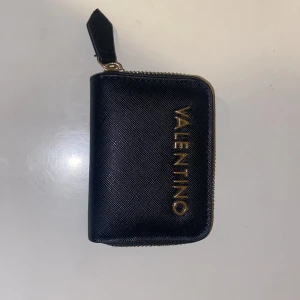 Valentino plånbok  - Är en plånbok där man kan ha mynt, sendlar, kort o.s.v!