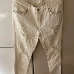 Jeans med utskärningar  - Vita jeans med utskärningar. Storlek 30. 