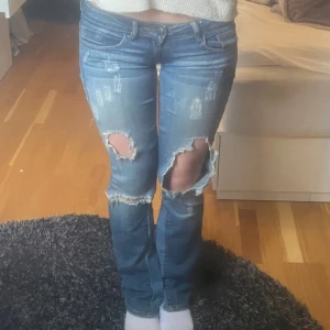 Lågmidjade jeans med hål - Intresseskoll! Snygga och jätte Lågmidjade jeans som är lite omsydda. Dom passar mig som vanligtvis har mellan 25x32 till 27x32. Funderar på att sälja för att dom inte kommer till så mkt användning! Skriv för frågor!