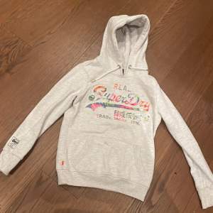 Här är min fina hoodie från Superdry som tyvärr inte kommer till användning längre🥲grå hoodie med färggladtext!!🔥