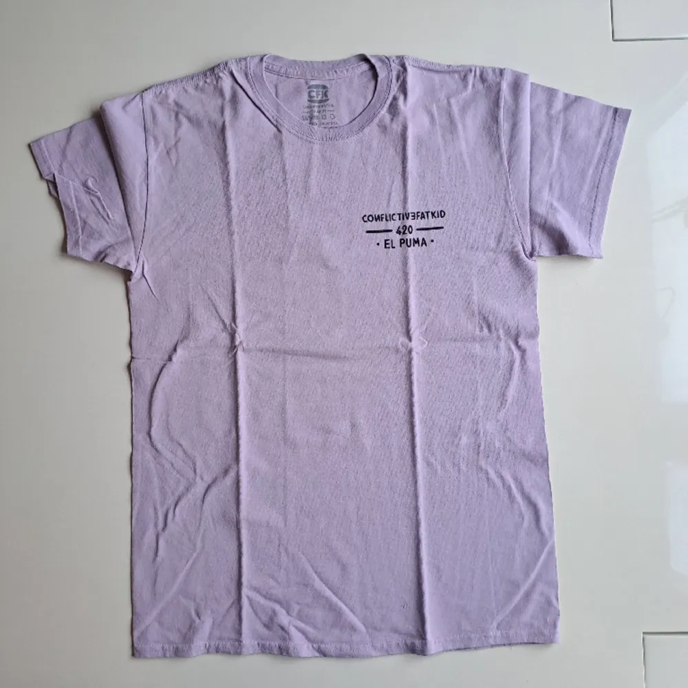Varumärke: Conflictivefatkid Produkt: T-Shirt Material: 100% bomull  Storlek: M Färg: Pastell lila Kondition: Mycket bra skick Mått: L: 70cm B: 50cm Kön: Herr/ Unisex . T-shirts.
