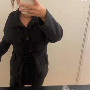 Gina tricot svart kappa - Helt ny kappa, aldrig använt den. Jackan är svårt att få tag på då den inte sälj längre. Helt ny skick, för fler bilder skriv gärna !