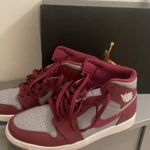Air Jordan 1 MID - Cherrywood red/white - Air jordans 1 mid som knappt är använda Storlek : EUR: 43 cm: 27.5cm Fint skick, den enda defekten är att höger är jättelite creasad men annars är dem som nya  Förpackningen ingår