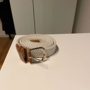 Flätat bälte - Fint flätat bälte i färgen vit. 