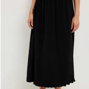 Svart kjol - Svart, fladdrig, lång kjol från Lager 157 liknande den i första bilden.