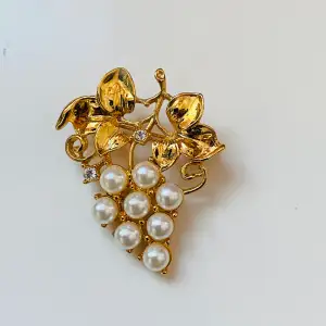 Vacker guldfärgad brosch med pärlor  Okänt material 