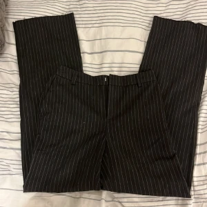Gina tricot kostymbyxor  - Kostymbyxor i storlek 34 från Gina Tricot. Mörkgråa med smala vita linjer på. De är i bra skick. 