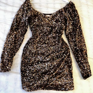 Paljettklänning guld - skitsnygg klänning från nelly!! brun med guldpaljetter, sitter så snyggt på kroppen och lösare i armarna. älskar denna, men något kort på mig🥲använd 1 gång! köptes för 700:-