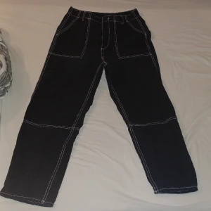 Svarta Cargo jeans med vita sömmar - Perfekta och väldigt sköna svarta cargo jeans. Användes max två gånger. Köpta för 350 kr men säljs för 120kr. Väldigt sköna jeans. De har inga slitningar/hål eller fläck.