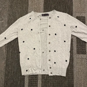 Kofta - Söt grå kofta med stjärnor. Sitter fint och inga skador. Aldrig använt 