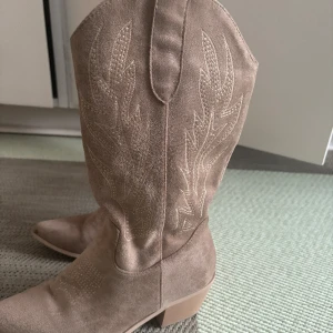 Cowboy boots - Ett par snygga beige cowboy boots med klack. Super snygga till sommaren. Använt 1-2 gånger. Nypris 699kr