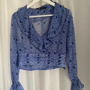 Topp Zara - Säljer en supersöt blå mönstrad blus från Zara i storlek M (passar även S)  Blusen är använd endast 1 gång och är i bra skick! Säljer då den inte kommer till användning  Hör av dig vid frågor💕💕