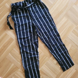 Randiga byxor Svart Vit stl.36  - Randiga tunna bomullsbyxor. Randig svart/vit i snyggt mönster. H&M stl 36. Paperbag-midja m resår. Knytskärt. Obetydligt använda. Nyskick, inga fel!