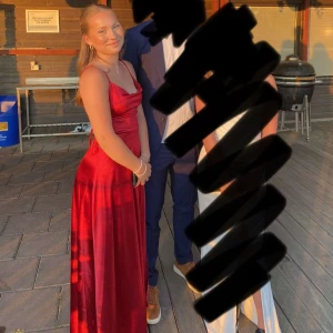 Röd balklänning  - Röd jättefin balklänning med slits och snörning i ryggen. Endast använd en gång. Som ny. Dragkedja bak och väldigt justerbar pga snörningen och justerbara axelband🥰skriv om du har frågor eller vill ha fler bilder