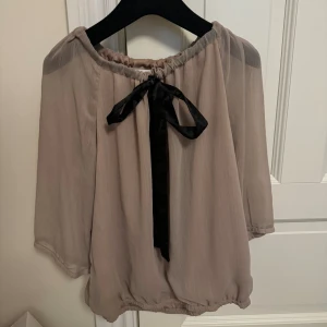 Blus med rosett - Jätte söt blus med rosett. Bra skick. Den är ljusrosa med svart band.