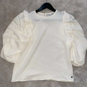 Vit volangblus  - Vitbeige volangblus med volangärmar, i nyskick 