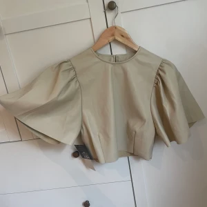 Festlig topp - Helt ny topp från Nelly.com, prislapp är frf kvar.  Den är i ett fejk läderaktikt material