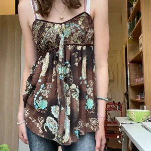 Blus/topp med guld - Jättefin sommartopp med gulddetaljer, på etiketten står det M-L men jag är en XS-S och den passar mig perfekt💗💗 skriv för fler frågor!