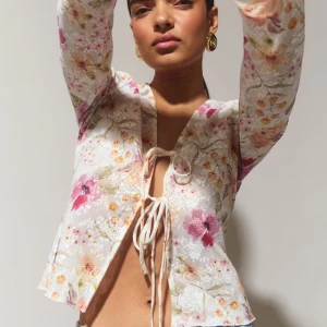 Gina Tricot Tie front Top - Tie front top från Gina Tricot i XS! Så så söt till sommaren, skir men inte genomskinlig så funkar utan något under om man vill ⭐️vit/beige med flera olika färger på blommor som orange och rosa 🫶🏼