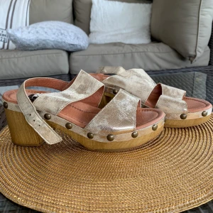 Guldiga träskor - Träskor med klack. Använda max tre gånger och i bra skick