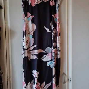 Sommarklänning  - Axelbandslös sommarklänning med blommigt mönster, den är i bra skick och har storlek xl och har väldigt stretchigt tyg