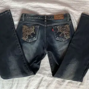Blågrå jeans m mönster på fram och bakfickor. Köpta i Sydkorea. Storlek står ej men typ 34/36/S. super skick! Lite tjockare material på insidan. Mönstret är väldigt fint broderat med små glitterstenar på! villig att sänka priset! innerben: 71 ish