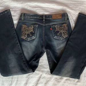 lågmidjade jeans - blågrå jeans m mönster på fram o bakfickor. köpta i sydkorea. stl står ej men typ 34/36/S. superskick! lite tjockare material på insidan. väldigt fint broderat mönster med små glitterstenar på! villig o diskutera pris! innerben 71cm o midjan 74cm💓