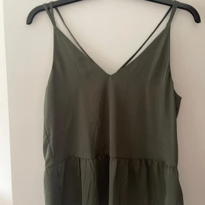 Linne med detalj i ryggen  - Säljer denna snygga toppen med korsande detalj i ryggen. Aldrig använd, köpt på H&M och är i storlek 36. ✨🌸 