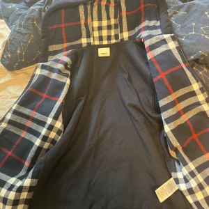 Burberry Zip hoodie - Sällsynt burberry kofta i marinblå med röd/vita detaljer storlek S men kan passa XS också då dene liten i storleken. Priset är inte hugget i sten. Pruta på!