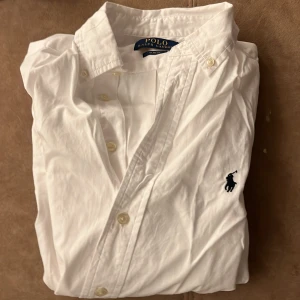 Ralph lauren skjorta  - Riktigt fet Ralph lauren skjorta som nu ska säljas för den är för liten. Storlek 14 som motsvarar ungefär 155-160. Köpte på nk barn tyvärr inget kvitto kvar. Men där emot är det i väldigt bra skick använd ett fåtal gånger. Frågor bara skriv👍🏽