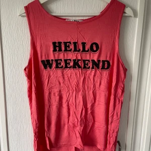 Hello weekend linne - Rött skönt linne med svart tryck. Skönt att ha på sig och bekvämt. Använt en handfull gånger. I bra skick. Stretchigt. Köpt på Ullared. 