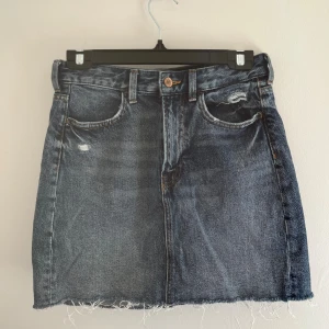 Jeanskjol - En jeanskjol från H&M med ”slitna” detaljer och rå kant. Kjolen har fram- och bakfickor samt en knapp och dragkedja framtill. ✨🌸