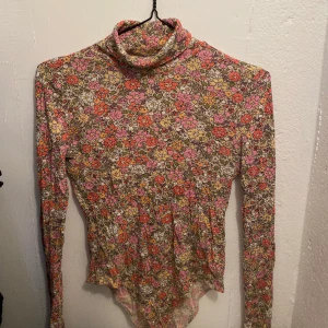 Blommig tröja - Blommig tight tröja med tumhål i storlek S från HM. Kontakta mig om du ska köpa eller om du har frågor💛