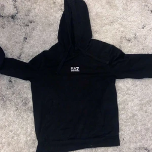 EA7 Hoodie - Riktigt skön och fet EA7 huvtröja. Bra skick, 9/10, ser nästan helt ny ut. Skriv till oss vid frågor eller funderingar! Pris går alltid att diskuteras vid snabb affär. 🤝