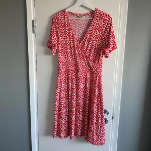 röd klänning med vita blommor - säljer denna superfina v-ringade klänningen från indiska❤️ den är röd med vita blommor och har suuuperskönt material