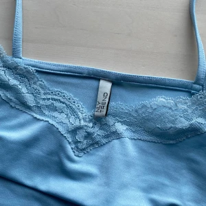 Ljusblå klänning  - Ljusblå tight klänningg med tunna axelbandoch spets från Nelly. Storlek S och i bra skick. Säljes då den var för liten. 