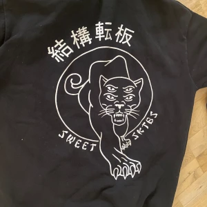 Svart Hoodie strl xs  - Snyggt tryck på rygg se bild  Tyvärr lite färgskillnaderna vid luva men man kan säkert färga svart på luvan där fram  Sweet sktbs
