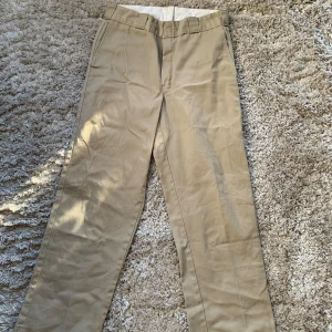 Dickies Byxor - Snygga beiga Dickies byxor med rak passform och som passar med allt. De är uppsprätta längst ned och insydda i midjan. Men det är enkelt fixat. Ca strl mellan 30/30-31/32. Kan mötas upp i ronneby/karlskrona, skriv meddelande isåfall.